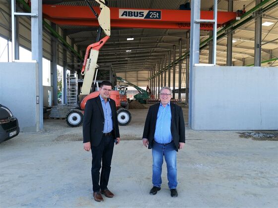 Mark Biesalski (von links) und Mirko Witkowski vor der neuen Fertigungshalle, die 2022 in Betrieb geht.